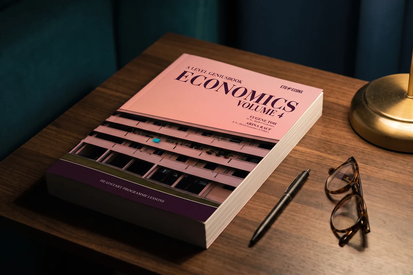 Economics Volume 4, the 2026 ETG Headstart textbook, on a desk with a pen and reading glasses